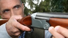 man aiming a rifle