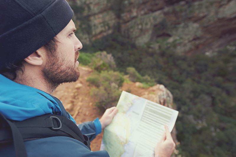 man holding a map in the wilderness