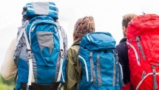 three people wearing backpacks