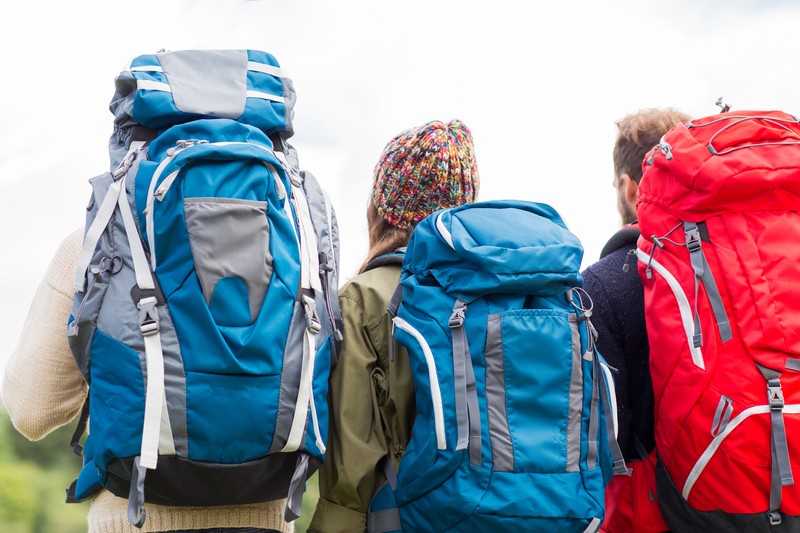 three people wearing backpacks