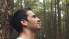 man by tree in forest