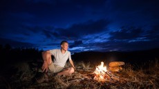 man having a campfire at night