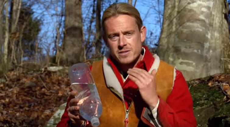 Fat Guys host holding up water bottle