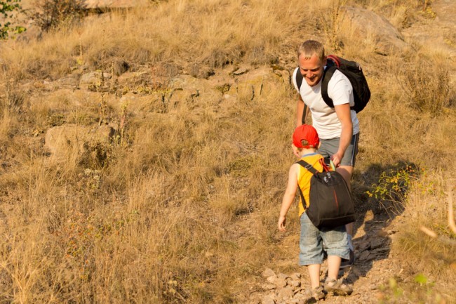 dad and son with backpack on mountain