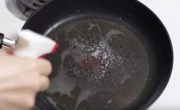 spraying a pan with windex