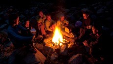 group of people sitting around a fire