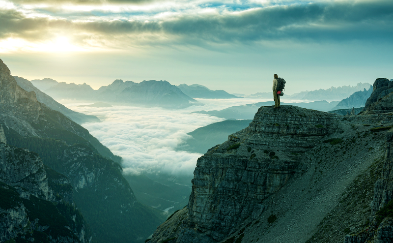 hiker-standing-on-the-edge-of-a-mountain