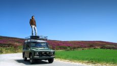 man-standing-on-car-adventure