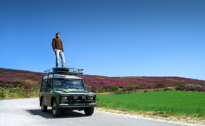 man-standing-on-car-adventure