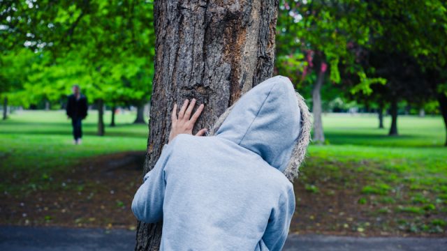 person-hiding-behind-tree