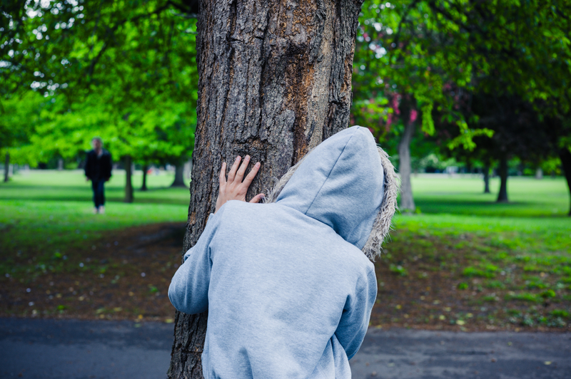 person-hiding-behind-tree