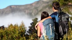 couple hiking with bags