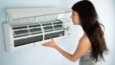 woman checking air conditioner