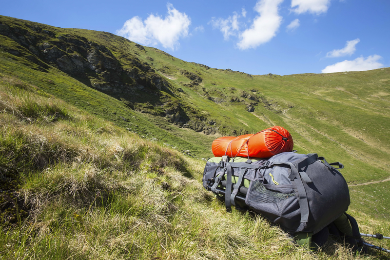 backpack on hill surrounded by mountains