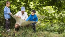 father teaching children in the wild