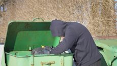 homeless man looking in garbage