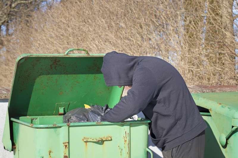 homeless man looking in garbage